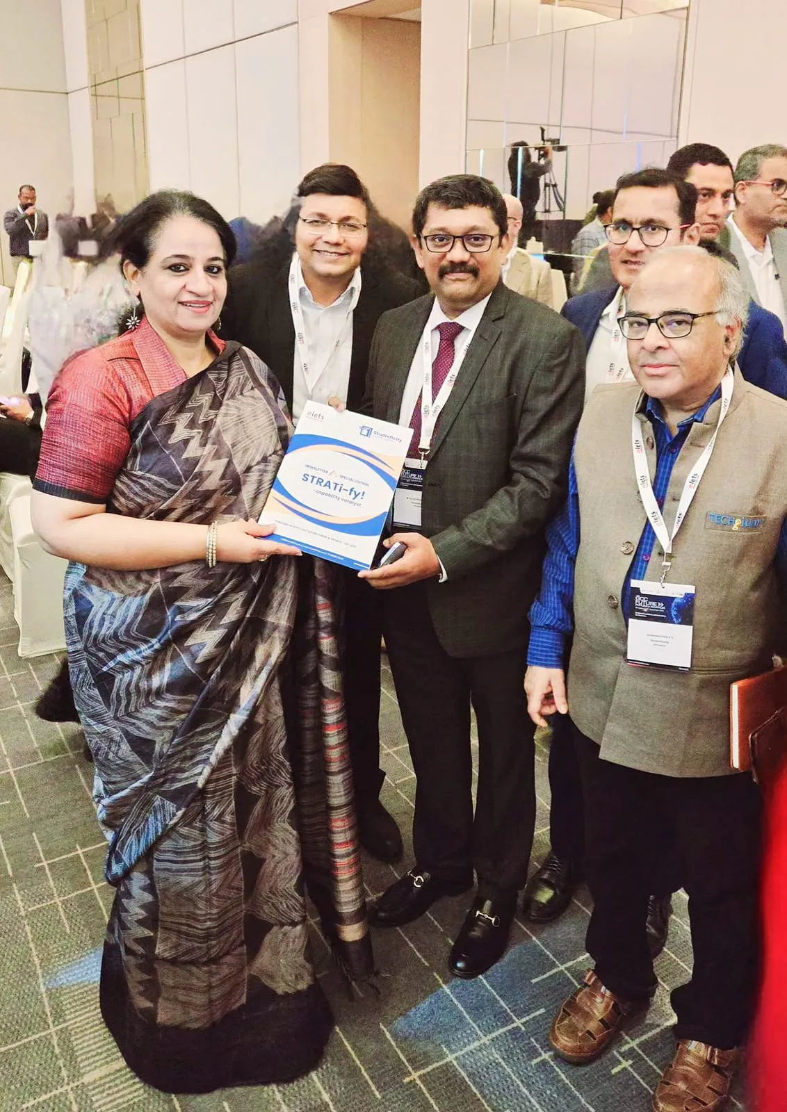 A copy of STRATi-fy!, StratInfinity's newsletter special edition, being presented to a delegate at the elets GCC Future Forum & Awards.