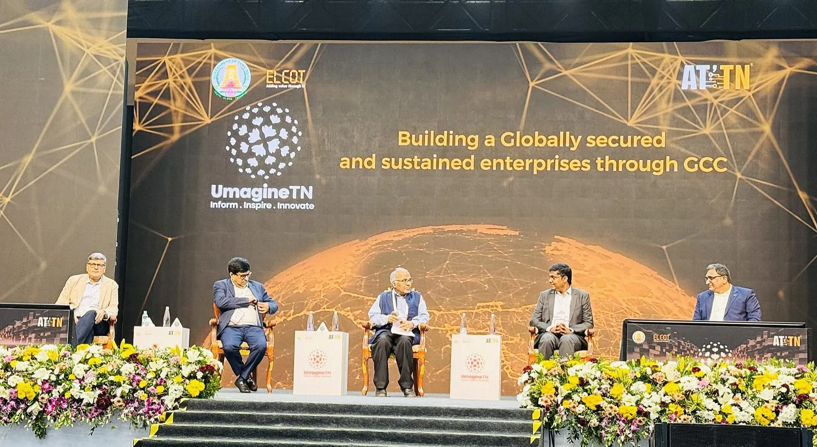 A five-member panel on stage at UmagineTN, beneath a banner reading 'Building a Globally secured and sustained enterprises through GCC'.
